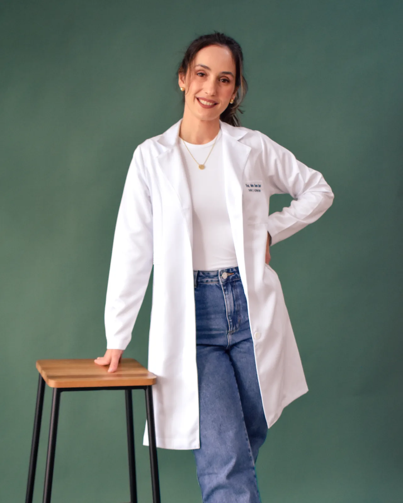 Dra. Náira Bueno Seixas em pé, de jaleco branco